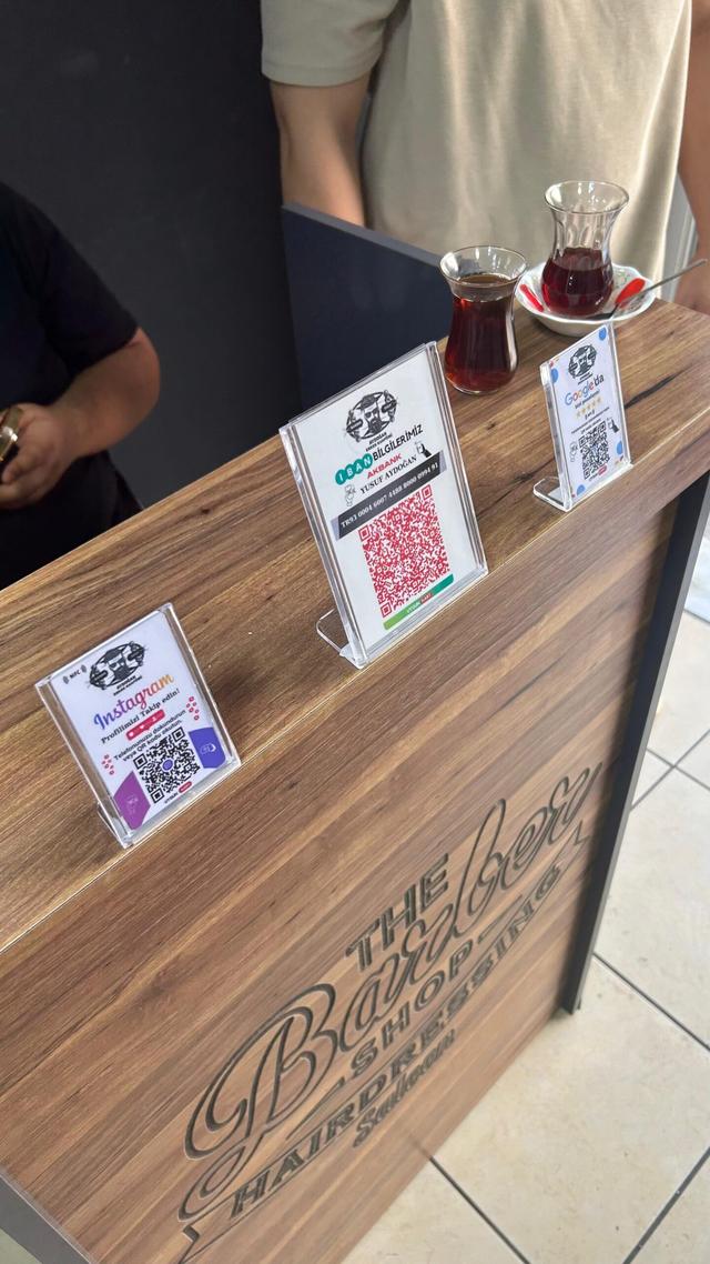 Berber salonunda tezgâh üzerindeki Instagram, IBAN ve Google yorum stand kartları